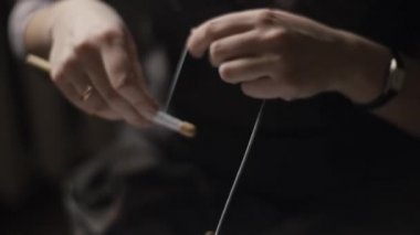Female hands weaving and tightening lace with bobbins
