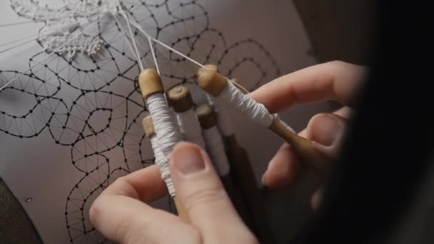 Detail close-up of female hands weaving lace with bobbins — Stok video