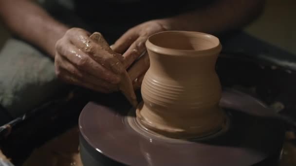 Artisan mannelijke handen vormen een kruik uit een klei op een pottenbakkerswiel in slow motion — Stockvideo