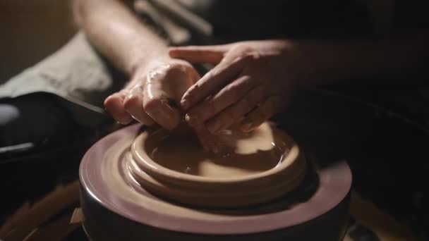 Artisan handen vormen een plaat van klei op een pottenbakkerswiel in slow motion — Stockvideo