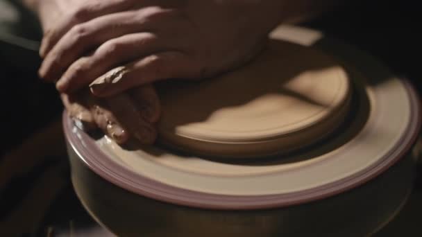 Mâini artizanale formând o placă din lut pe o roată de olar în mișcare lentă — Videoclip de stoc