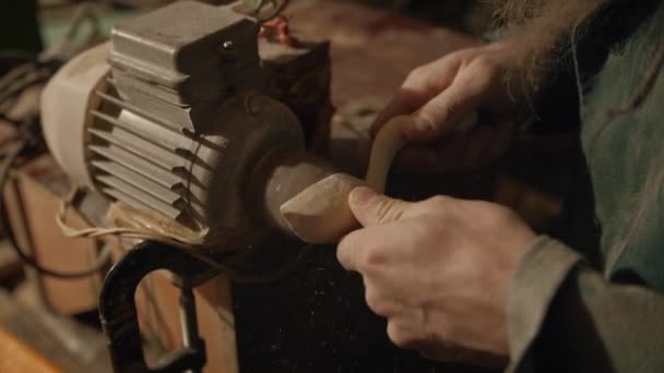 Moagem de uma colher de madeira artesanal em uma lixadeira — Vídeo de Stock