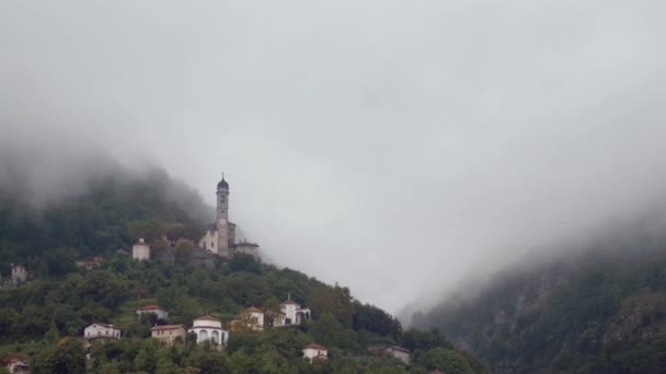 Iglesia en una montaña rodeada de nubes en el lago como — Vídeos de Stock