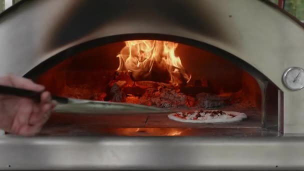 Poner una pizza en un horno de leña — Vídeos de Stock