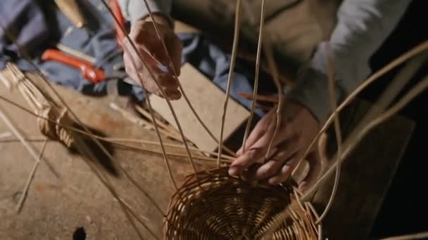 Плетіння кошика з гілок верби на столі — стокове відео