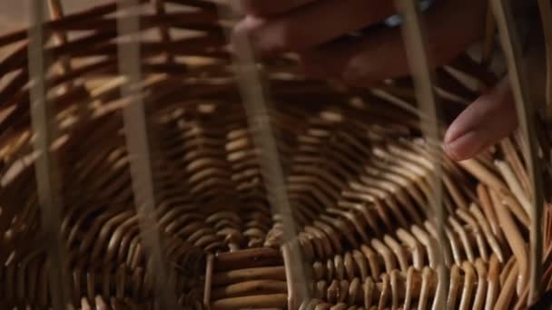 Крупный план рук, сплетающих корзину из ивовых ветвей — стоковое видео