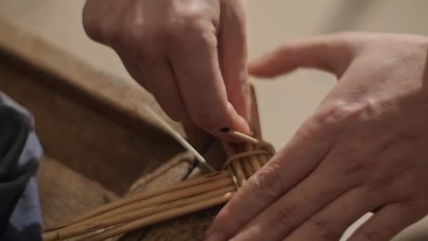 Nahaufnahme von Händen, die einen Korb aus Weidenzweigen weben Stockvideo