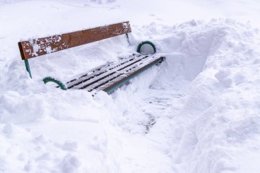 Yoğun kar yağışı sonrası kar yığınından çıkarılan boş bank. Kış günü. Beyaz, yumuşak kar