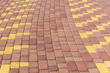 Kırmızı ve sarı kaldırımlı kaldırım taşları porselen taş parçalarından yapılmıştır. Doğal doku, arkaplan