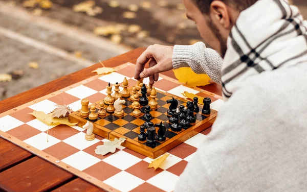 top view: a man plays chess on a table in an autumn park at the play area