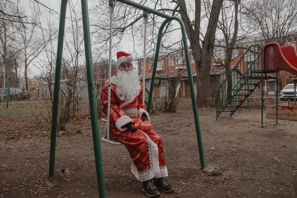 Man Verkleed Als Kerstman Met Mandarijnen Een Pakket Zit Een — Stockfoto