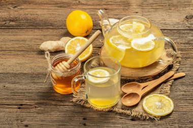 Tahta arka planda cam bir fincanda limonlu ve ballı sıcak zencefil çayı. Alternatif tıp, soğuk algınlığı ve grip için doğal ev tedavisi, kopyalama alanı
