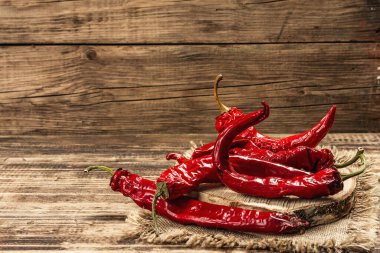 Tahta arka planda olgun kırmızı biber. Farklı yiyecekler için geleneksel malzeme, aşçılık arkaplanı, metin için yer