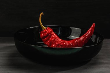 Olgun acı biber sosu ve siyah ahşap arka planda bütün sebzeler. Farklı yiyecekler için geleneksel malzeme, mutfak arkaplanı, kapat