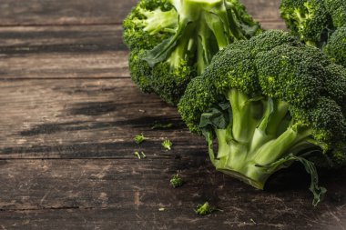 Eski ahşap arka planda yeşil taze brokoli. Diyet için olgun sebzeler, sağlıklı yiyecekler, organik yiyecekler. Düz konum, makro fotoğraf, seçici odak, kopyalama alanı