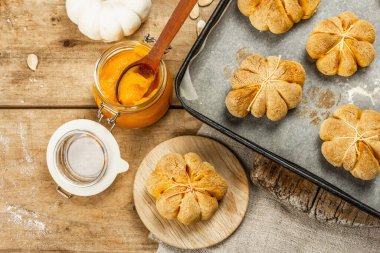 Balkabağı çörekleri ya da bisküviler, geleneksel sonbahar pişmiş ürünler. Mevsimlik ev yapımı yemekler ve sonbahar dekorasyonu. Eski tahta arka plan, üst görünüm