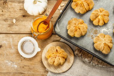 Balkabağı çörekleri ya da bisküviler, geleneksel sonbahar pişmiş ürünler. Mevsimlik ev yapımı yemekler ve sonbahar dekorasyonu. Eski tahta arka plan, üst görünüm