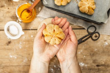 Balkabağı çörekleri ya da bisküviler, geleneksel sonbahar pişmiş ürünler. Kadın eli kurabiyeleri tutar. Mevsimlik ev yapımı yemekler ve sonbahar dekorasyonu. Eski tahta arka plan, üst görünüm