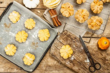 Balkabağı çörekleri ya da kurabiyeler, geleneksel sonbahar pişmiş yiyecekler. Bisküvi hazırlıyorum. Mevsimlik ev yapımı yemekler ve sonbahar dekorasyonu. Eski tahta arka plan, üst görünüm