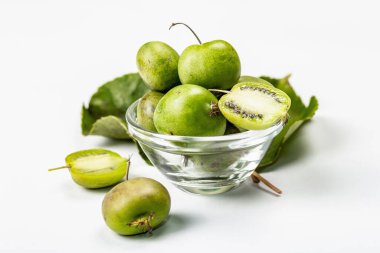 Olgun Actinidia arguta ya da kivi beyaz arka planda izole edilmiştir. Taze meyve dalları, yeşil yapraklar, maket, şablon