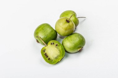 Olgun Actinidia arguta ya da kivi beyaz arka planda izole edilmiştir. Taze meyve dalları, yeşil yapraklar, maket, şablon
