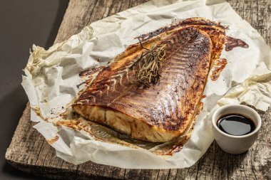 Fırında Pollock (Pollachius virens) fileto. Sağlıklı yaşam tarzı için teriyaki soslu balık. Biberiye, soya sosu, parşömen. Ahşap tezgah, siyah taş zemin, kopyalama alanı