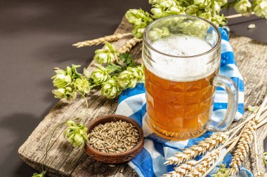 Oktoberfest seti. Hafif bira, çivili tahıl, hop. Geleneksel Alman mutfağı, festival yemekleri. Kupa, keten peçete, taş beton zemin, kopyalama alanı