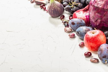 Mavi, kırmızı ve mor yiyecek. Meyve ve sebzelerin aşçılık geçmişi. Taze incir, erik, soğan, patlıcan, üzüm, lahana, elma, sarımsak, köpek ağacı, nar. Beyaz arkaplan, modaya uygun sert ışık