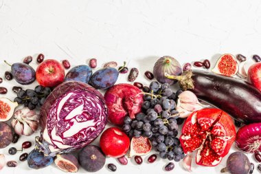 Mavi, kırmızı ve mor yiyecek. Meyve ve sebzelerin aşçılık geçmişi. Taze incir, erik, soğan, patlıcan, üzüm, lahana, elma, sarımsak, köpek ağacı, nar. Beyaz arkaplan, modaya uygun sert ışık