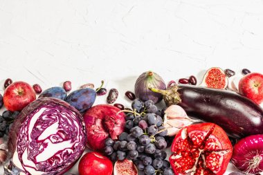 Mavi, kırmızı ve mor yiyecek. Meyve ve sebzelerin aşçılık geçmişi. Taze incir, erik, soğan, patlıcan, üzüm, lahana, elma, sarımsak, köpek ağacı, nar. Beyaz arkaplan, modaya uygun sert ışık