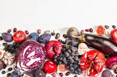 Mavi, kırmızı ve mor yiyecek. Meyve ve sebzelerin aşçılık geçmişi. Taze incir, erik, soğan, patlıcan, üzüm, lahana, elma, sarımsak, köpek ağacı, nar. Beyaz arkaplan, modaya uygun sert ışık