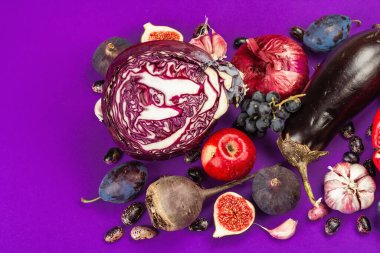 Mavi, kırmızı ve mor yiyecek. Meyve ve sebzelerin aşçılık geçmişi. Taze incir, erik, soğan, patlıcan, üzüm, lahana, elma, sarımsak, köpek ağacı, nar, pancar. Menekşe arkaplan, düz yatak
