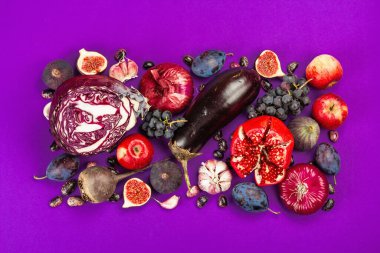 Mavi, kırmızı ve mor yiyecek. Meyve ve sebzelerin aşçılık geçmişi. Taze incir, erik, soğan, patlıcan, üzüm, lahana, elma, sarımsak, köpek ağacı, nar, pancar. Menekşe arkaplan, düz yatak