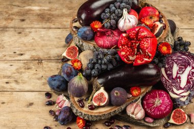 Mavi, kırmızı ve mor yiyecek. Meyve ve sebzelerin aşçılık geçmişi. Taze incir, erik, soğan, patlıcan, üzüm, lahana, elma, sarımsak, köpek ağacı, nar, pancar. Tahta ayakta ve eski tahtalar