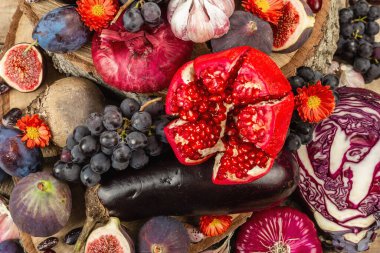 Mavi, kırmızı ve mor yiyecek. Meyve ve sebzelerin aşçılık geçmişi. Taze incir, erik, soğan, patlıcan, üzüm, lahana, elma, sarımsak, köpek ağacı, nar, pancar. Tahta ayakta ve eski tahtalar