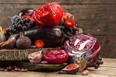 Mavi, kırmızı ve mor yiyecek. Meyve ve sebzelerin aşçılık geçmişi. Taze incir, erik, soğan, patlıcan, üzüm, lahana, elma, sarımsak, köpek ağacı, nar, pancar. Tahta ayakta ve eski tahtalar