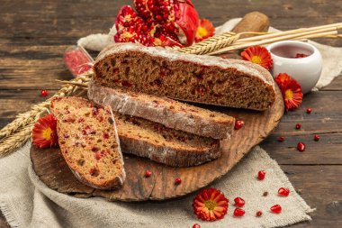 Tatillerde yaban mersinli tam tahıllı ekmek. Taze ev yapımı fırın, olgun nar, kuru dikenler. Sonbahar kasımpatıları, eski ahşap arka plan, yakın plan.