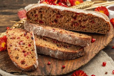 Tatillerde yaban mersinli tam tahıllı ekmek. Taze ev yapımı fırın, olgun nar, kuru dikenler. Sonbahar kasımpatıları, eski ahşap arka plan, yakın plan.