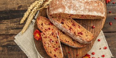 Tatillerde yaban mersinli tam tahıllı ekmek. Taze ev yapımı fırın, olgun nar, kuru dikenler. Sonbahar kasımpatıları, eski ahşap zemin, afiş biçimi