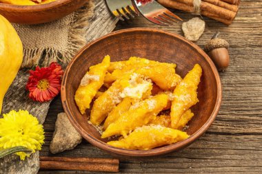 Balkabağı gnocchi ya da İtalyan böreği. Süzme peynirli sağlıklı vejetaryen kabağı. Sonbahar dekoru, güz yaprakları, kozalaklar, olgun balkabakları, çiçekler ve baharatlar. Eski ahşap arka plan, kapat