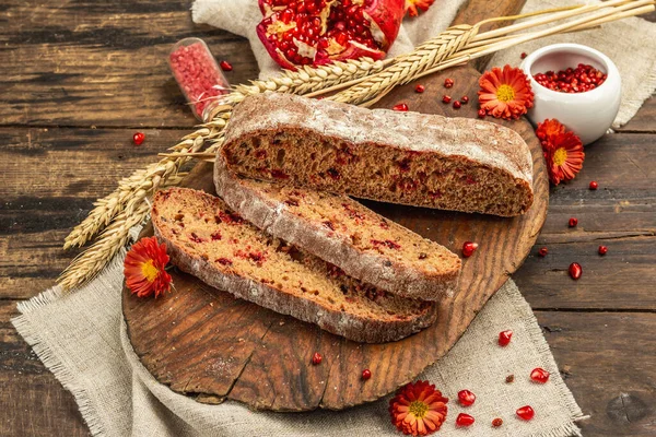 Tatillerde yaban mersinli tam tahıllı ekmek. Taze ev yapımı fırın, olgun nar, kuru dikenler. Sonbahar kasımpatıları, eski ahşap zemin, kopyalama alanı