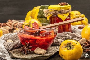 Ayva reçeli ya da esmer şekerle demlenmiş konfeksiyon. Olgun meyveler, tatlı tatlı, mis kokulu baharatlar. Moda ahşap standı, eski tahta arka planı, kapat