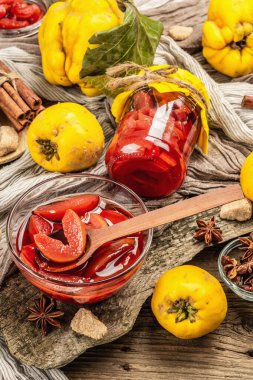 Ayva reçeli ya da esmer şekerle demlenmiş konfeksiyon. Olgun meyveler, tatlı tatlı, mis kokulu baharatlar. Moda ahşap standı, eski tahta arka planı, kapat