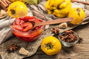 Ayva reçeli ya da esmer şekerle demlenmiş konfeksiyon. Olgun meyveler, tatlı tatlı, mis kokulu baharatlar. Moda ahşap standı, eski tahta arka planı, kapat