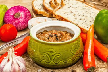 Taze sebzeli vejetaryen güveci. Doğranmış malzemeler, ekmek, çatal bıçak takımı ve baharatlar. Ahşap arkaplan, kapat