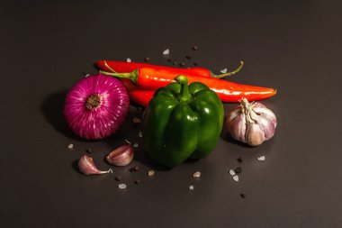 Aşçılık geçmişi. Siyah taş arka planda taze sebzeler. Renkli ürünlerin toplanması, düz yatış, modaya uygun sert ışık, karanlık gölge, kapat