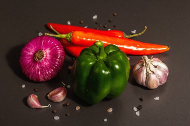 Aşçılık geçmişi. Siyah taş arka planda taze sebzeler. Renkli ürünlerin toplanması, düz yatış, modaya uygun sert ışık, karanlık gölge, kapat