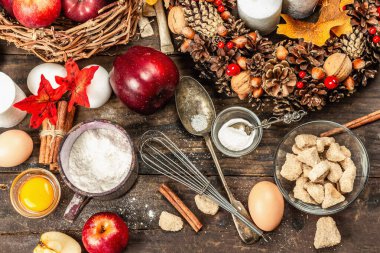 Sonbahar pişirme konsepti. Mutfak gereçleri, malzemeler seti, mevsimlik dekorasyon. Elma ve baharatlı tatlı hamur işleri pişiriyorum. Eski ahşap zemin, üst manzara