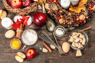 Sonbahar pişirme konsepti. Mutfak gereçleri, malzemeler seti, mevsimlik dekorasyon. Elma ve baharatlı tatlı hamur işleri pişiriyorum. Eski ahşap zemin, üst manzara