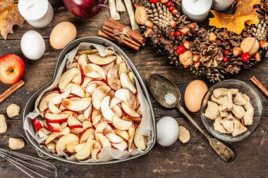 Elma Charlotte pişirmeye hazır. Mutfak gereçleri, malzemeler seti, mevsimlik dekorasyon. Baharatlı tatlı hamur işleri pişiriyorum. Eski ahşap zemin, üst manzara